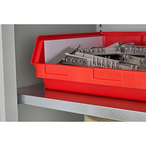 Boîte en plastique rouge remplie de composants gris, sur une étagère dans une armoire.