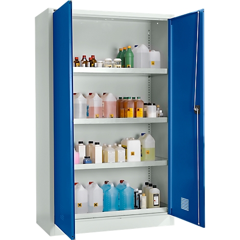 Armoire ouverte avec portes bleues remplie de bouteilles et de contenants de différentes tailles. Des autocollants de symboles de danger sont visibles.