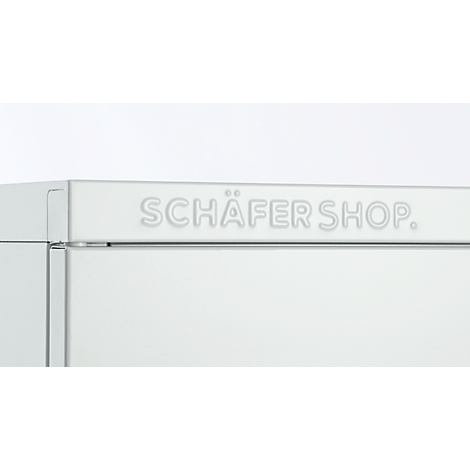 Gros plan du texte 'SCHÄFER SHOP' en gris clair sur une surface blanche.