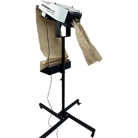 Verpakkingsmachine met papieren zakken. De machine is zwart en wit, op een standaard met wielen. Een papieren zak is in gebruik.