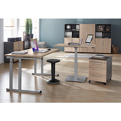 Bureau avec deux tables réglables en hauteur, un tabouret et des classeurs. Un ordinateur portable est sur une table et une tablette sur l'autre.