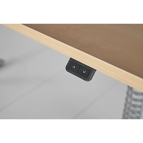 Gros plan des boutons de commande sous le plateau de la table. Touches fléchées pour le réglage de la hauteur.