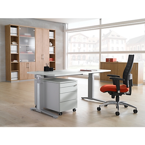 Bureau avec bureau, meuble mural et chaise de bureau. Une fenêtre montre un paysage urbain. La chaise a une assise rouge.