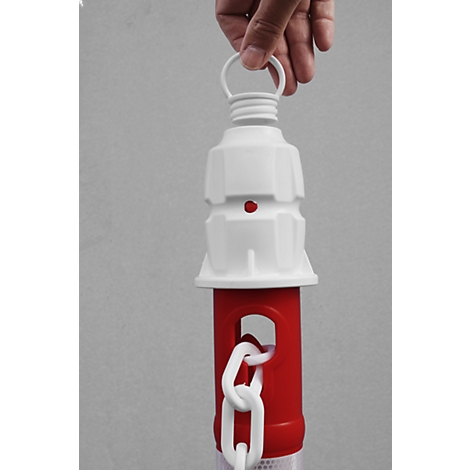Close-up of a red and white barrier pole held by a hand, featuring a white chain.