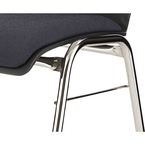 Gros plan sur un pied de chaise, en métal poli. L'assise est en tissu sombre et texturé.
