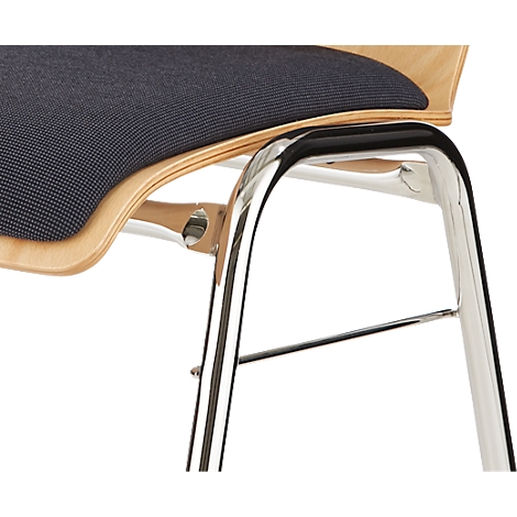 Détail d'une chaise. L'assise est recouverte de tissu bleu foncé, le cadre est en métal chromé.