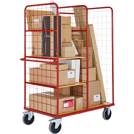 Chariot rouge avec des marchandises. Grillage sur les côtés, rempli de boîtes, de colis et de longs articles.