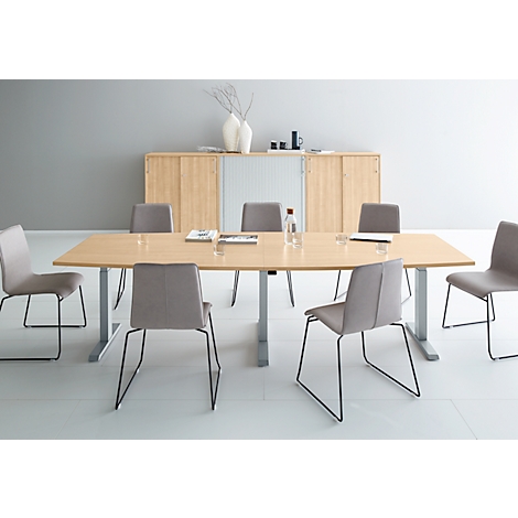 A conference table with chairs in a modern office. There are water bottles and glasses on the table.