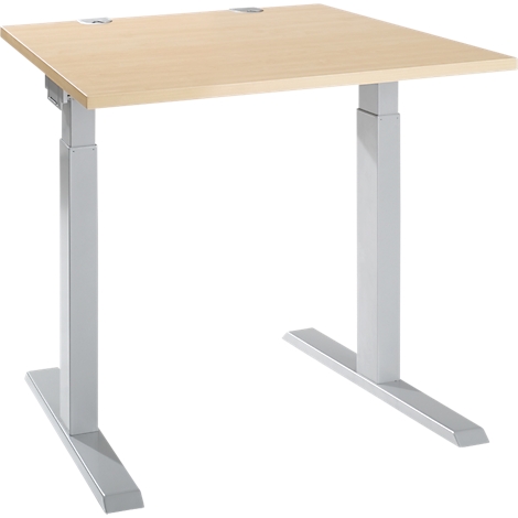 A height-adjustable desk with a beige tabletop and silver legs. It stands against a white background.