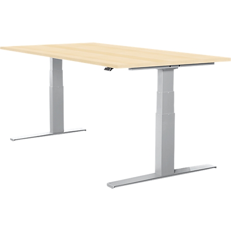A height-adjustable desk. Light wood top on silver, T-shaped legs. Control for height adjustment.