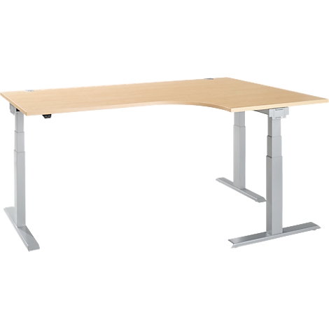 L-shaped desk in light wood with gray, height-adjustable frame. The tabletop has a rounded corner.