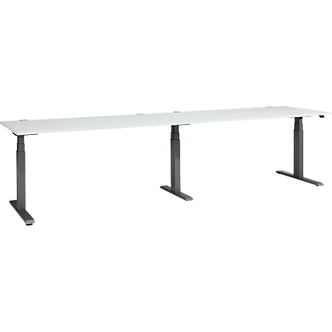 Long white desk with height-adjustable dark legs.