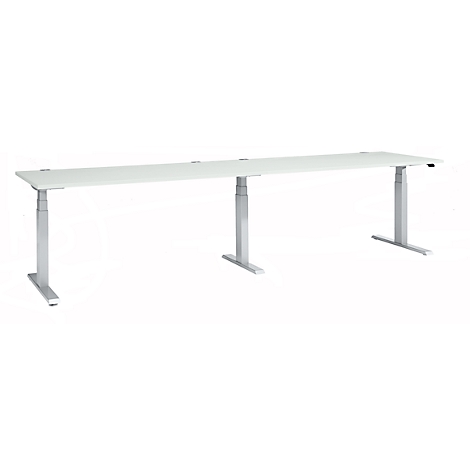 A white, elongated desk with adjustable silver legs. On a light background.