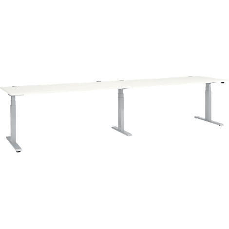 A long, white desk with silver height-adjustable legs, set against a white background.