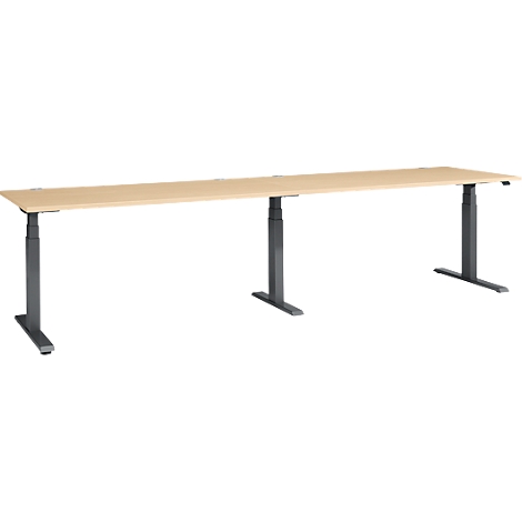 A long, rectangular, height-adjustable desk. The tabletop is light brown, the legs are dark gray.