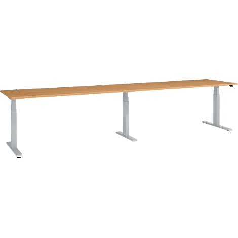 A long, height-adjustable desk with a wooden look and silver legs.