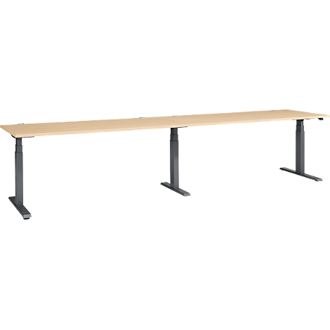 A long, beige desk with gray, height-adjustable legs. The desk stands against a white background.