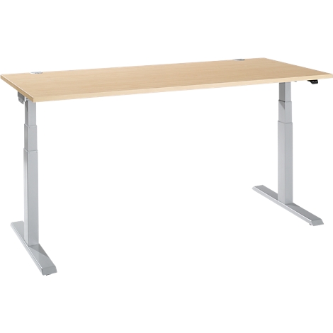 A height-adjustable desk made of light wood and silver legs stands against a white background.