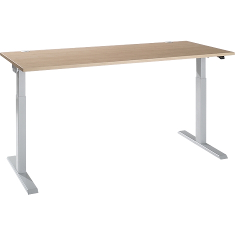 An adjustable-height desk with a light wood top and silver legs, set against a white backdrop.