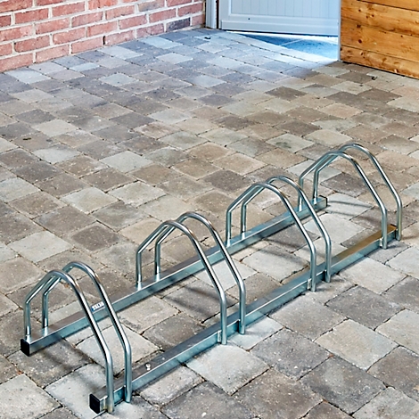 Metalen fietsenrek op klinkers buiten.