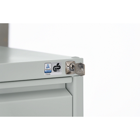 Detailed view of a gray cabinet with a key in the lock, quality seal.