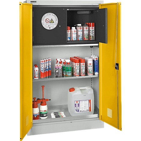 Gelber Sicherheitschrank, geöffnet. Gefüllt mit Sprays, Flaschen und Kanistern. Gefahrenzeichen am Schrank.