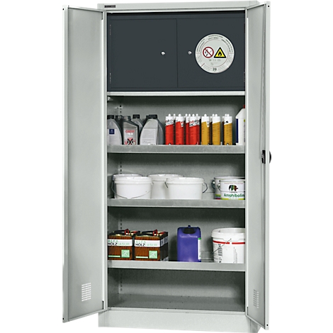 Offener grauer Schrank mit Chemikalien, u.a. Farbeimern, Kanistern und Warnschild.