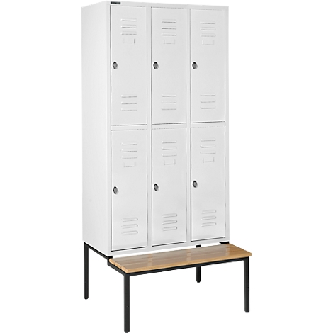 Witte locker kast met 6 compartimenten, op een houten bankje met zwarte poten. Deuren met kleine knoppen.