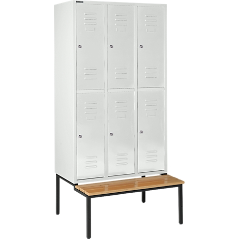 Witte locker met zes deuren, inclusief een houten bank met zwarte poten.