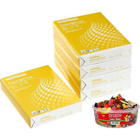 Mehrere Papierstapel mit gelber Verpackung und der Aufschrift Paper@Print. Dazu eine Schale Haribo Color-Rado.