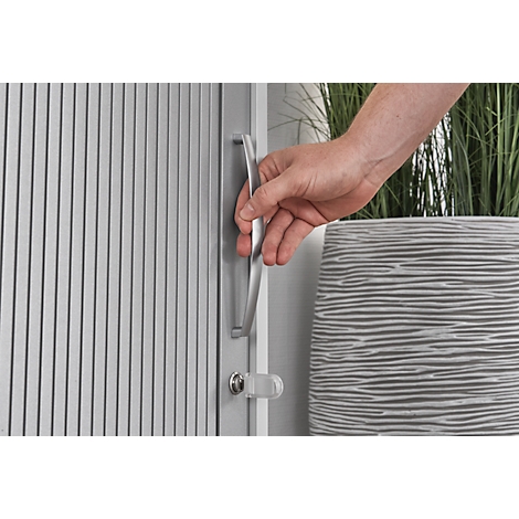 Hand opening a door handle. The door has vertical slats, the handle is silver, with a latch below.