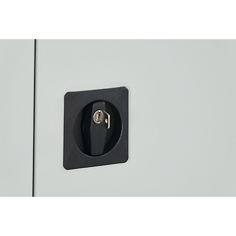Black rotary latch with key in a square holder on a light grey surface.
