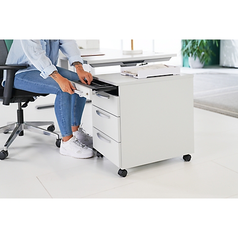 Person opens a drawer on a white mobile pedestal. She is sitting on an office chair.
