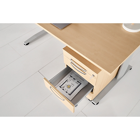 Office desk with open drawer. There is a document in it. The desk has a wood look and silver legs.