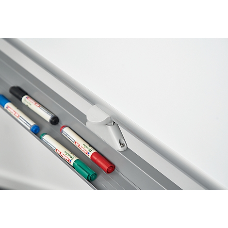 Close-up of a whiteboard with colorful pens. Several pens rest on a silver tray, with text on the side.