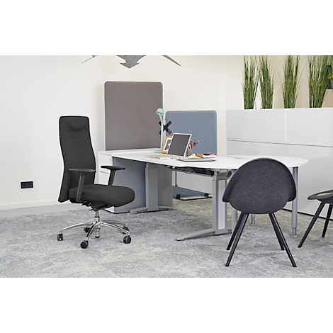 Office with black office chair, desk, laptop, and grey chairs. Office with green plants and fabric partition walls.