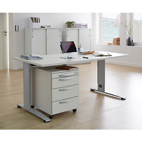 White desk in modern office, with tablet, mobile pedestal, and window view.