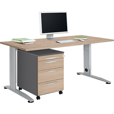 Hellbrauner Schreibtisch mit Schubladenschrank und silbernen Beinen. Auf dem Tisch stehen ein Monitor, Tastatur und Bücher.