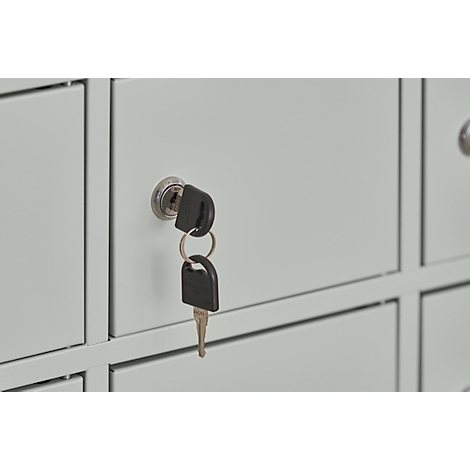 Close-up of a light gray cabinet with a key in the keyhole.