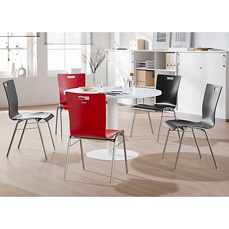 A round table with four chairs in red, black and grey in a modern dining room.