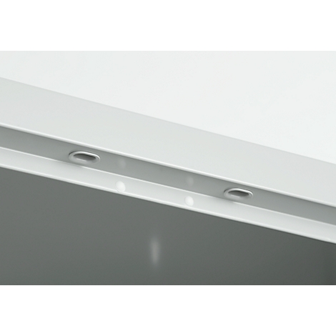 Close-up van een witte constructie met twee ovale openingen in een rechte lijn. Boven en onder de constructie is een witte achtergrond.