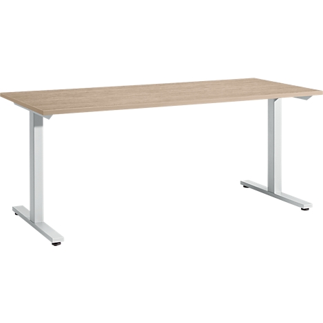 A light-colored, rectangular desk with wood grain, supported by white, T-shaped legs.