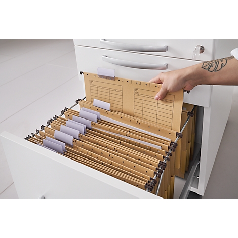 A hand reaches into an open drawer filled with hanging file folders. One of the folders has text on it.