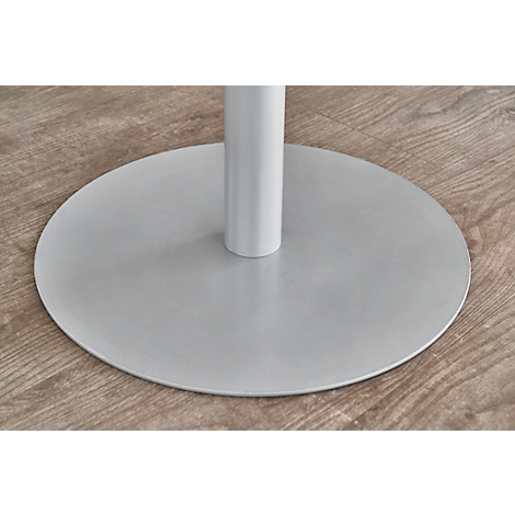 Close-up of a white table base with a round, gray base on a light wooden surface.