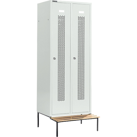 Un casillero blanco con dos puertas y ranuras de ventilación. Debajo, un banco de listones de madera, sobre patas negras.