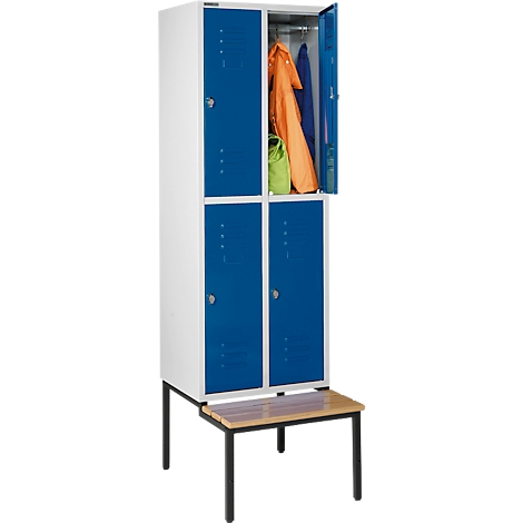 Un casillero blanco y azul con una puerta abierta llena de ropa. Un banco debajo.
