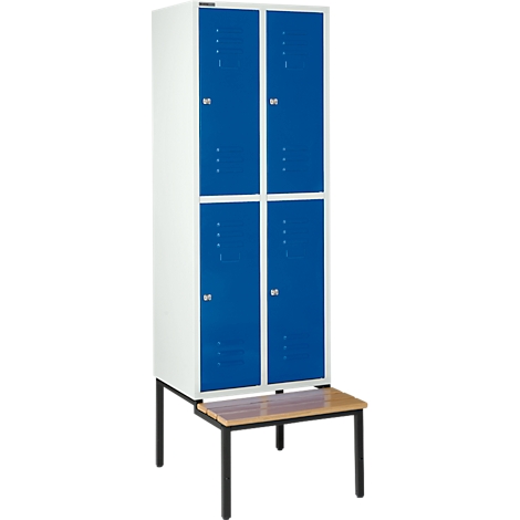 Armario blanco con cuatro puertas azules, sobre un podio marrón con patas negras.