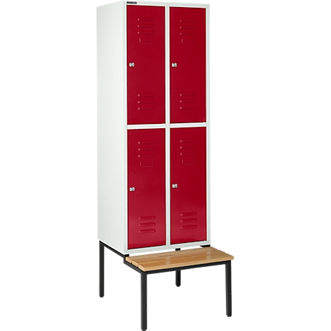 Un casillero blanco con cuatro puertas rojas. Debajo hay un banco de madera sobre patas negras.