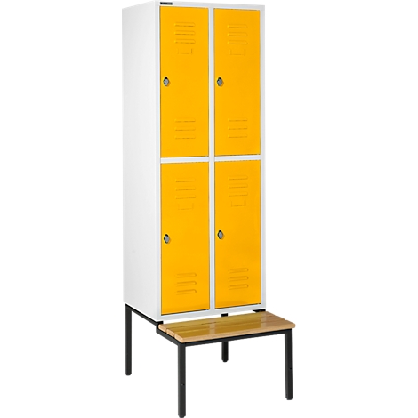 Un armario blanco con cuatro puertas amarillas. Se encuentra sobre una tabla marrón con patas negras.