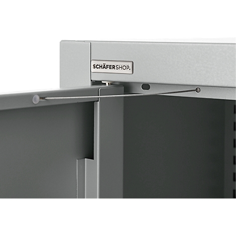 Detailed view of a gray metal cabinet with the door partially open. The top reads "SCHÄFERSHOP".